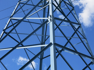 geometric design of a power line tower against a blue sky background