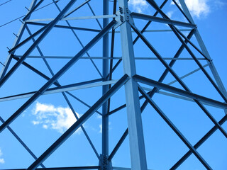 geometric design of a power line tower against a blue sky background