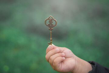 Big vintage key macro. Retro key in a man's hand. The key to success.