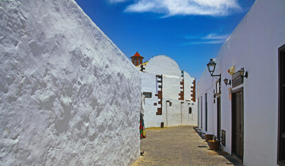 Beautiful bright white typical canarian village, small empty alleyway, blue sky - Teguise, Lanzarote