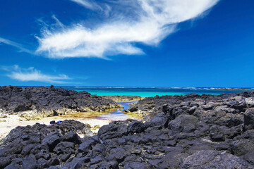 Fototapeta na wymiar El Cotillo - Faro del Toston: Beautiful beach, natural pools between black volcanic rocks and turquoise ocean horizon north Fuerteventura against clear blue sky