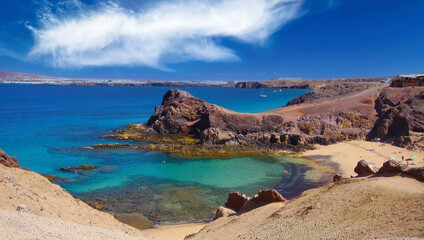 Fototapeta na wymiar Beautiful coast landscape, secluded blue turquoise lagoon, white sand beach, dramatic red cliffs, blue sky and sea - Playa Papagayo, Playa Blanca - Lanzarote