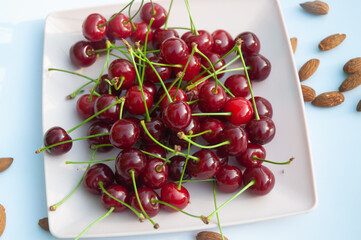 Cherries on a plate, and almonds.