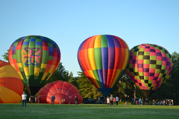 Colorful hot air balloons filling up with air
