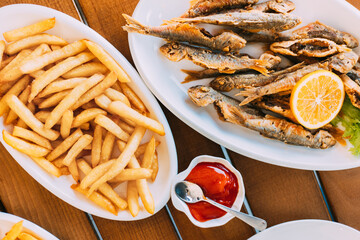 french fries and grilled fishes. fish and chips. Dish with Mullet Fish With orange. Fried fry small...