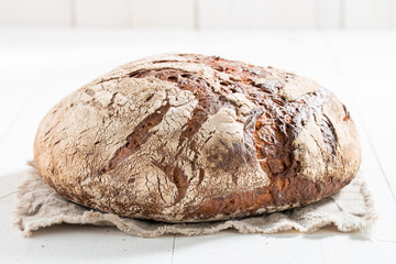 Homemade bread with whole grains on white table