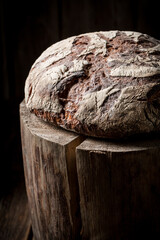 Big and homemade loaf of bread on wooden stump