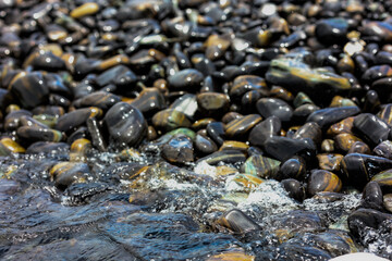 Absract black pebble on the beach for nature background.