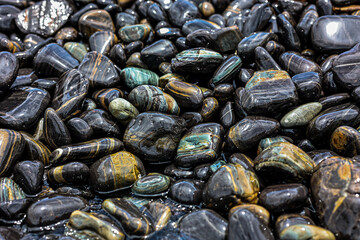 Absract black pebble on the beach for nature background.