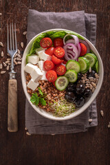 Diet Greek salad with groats, feta cheese and vegetables.