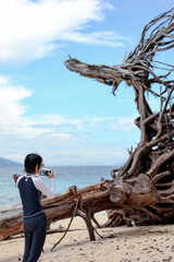 Asian woman use smartphone taking sea view and roadside photos in southern Thailand. Travel vacation concept.	