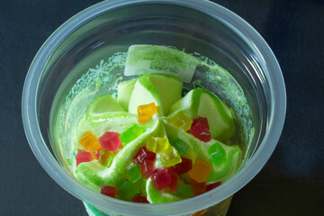 Sweet ice cream in a plastic cup on the table
