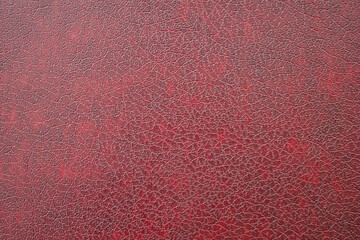 Close-up of dark red imitation leather, leatherette as texture or background.