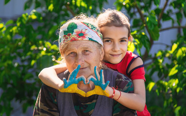 Child and grandmother hand drawn flag of Ukraine. Selective focus.