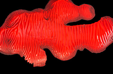 Paint splat in red on black background looks like an alien creature.