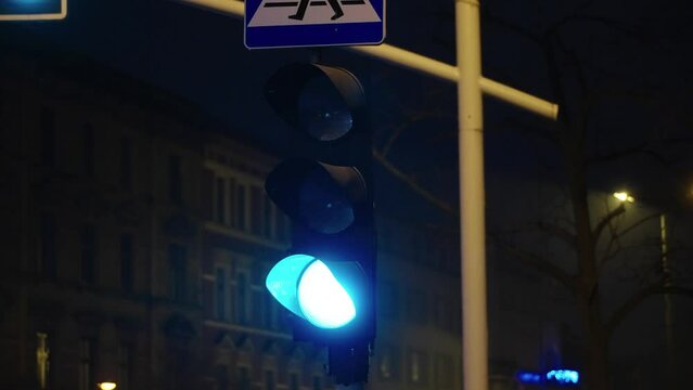 Zielone światło nocą na skrzyzowaniu dr&oacute;g 