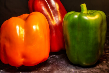 Three bell peppers  on dark marble background.