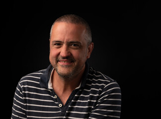 Fototapeta premium Smiling man on black background with copy space