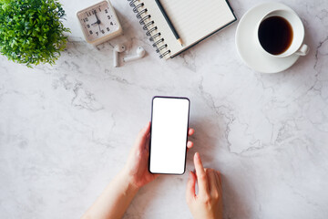 Mockup picture of business woman’s hands holding smart phone with white blank screen in modern...