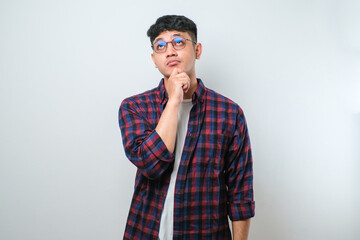 Young handsome man wearing casual shirt thinking worried about a question, concerned and nervous with hand on chin