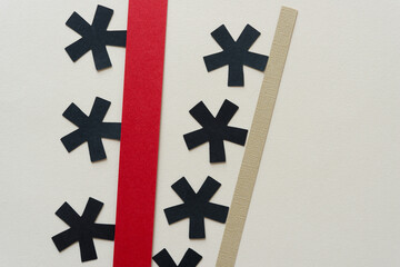 six paper asterisks fixed to red and beige paper stripes on beige ground