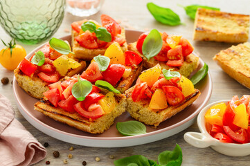 Bruschetta with fresh tomatoes and basil on a pink plate. Italian healthy snack. Selective focus 
