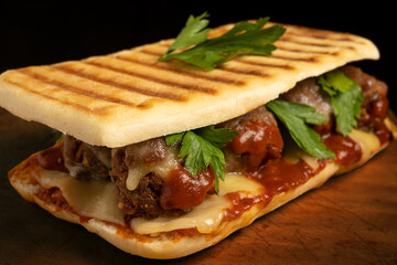 Meatball sandwich with marinara sauce, mozzarella and parsley