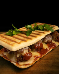Meatball sandwich with marinara sauce, mozzarella and parsley