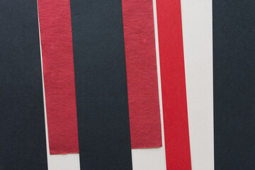 black and red paper pieces arranged on a gray beige background (stripes)