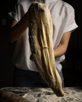 Lady chef making pizza dough, stretching dough