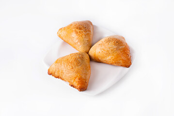 samosa made of dough with filling in a white plate on a white background