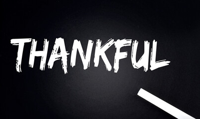 THANKFUL Text on Black Chalkboard with a piece of chalk