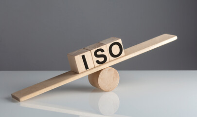 ISO text on wooden cubes on a wooden balance , business concept
