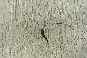 Peeling paint of a house wall. Wall with cracks on the wall paint, brazilian grafiato texture.