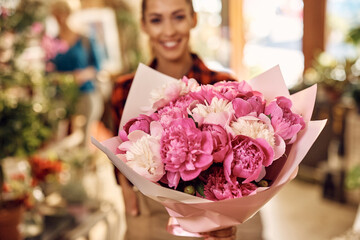 Close up of florist holding beautiful floral bouquet at flower shop.