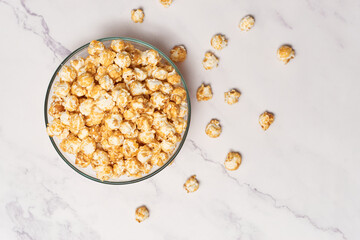 Bowl with delicious caramel popcorn on white table