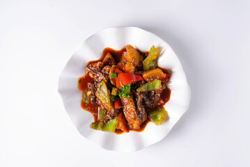 жареное мясо с овощами в соусе. на белом фоне