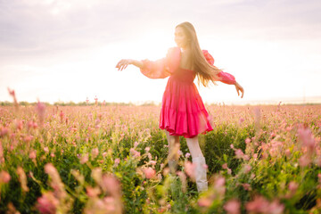 Naklejka na ściany i meble Happy woman in the blooming field. Nature, vacation, relax and lifestyle. Summer landscape. Fashion, style concept.