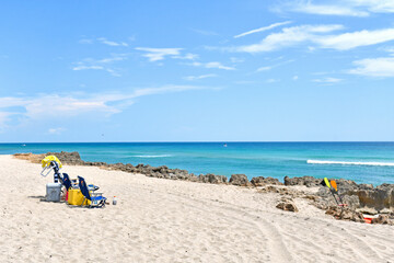 Beachchairs set up for a Summer beach day in Stuart Rocks Beach in Stuart, Florida in Martin County - obrazy, fototapety, plakaty