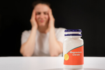 A tired woman and a jar of magnesium citrate. Dietary supplements for fatigue, irritability and insomnia - obrazy, fototapety, plakaty
