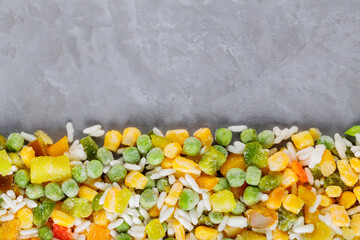 Mixed frozen vegetables with rice on a gray background. Frozen vegetables retaining all nutrients:...