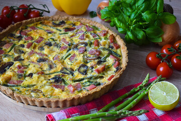 Quiche Lorraine Tart. Quiche is a tart consisting of pastry crust filled with eggs custard and pieces of cheese, bacon, and asparagus.