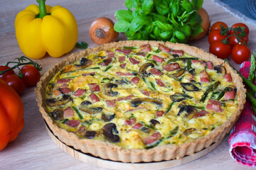 Quiche Lorraine Tart. Quiche is a tart consisting of pastry crust filled with eggs custard and pieces of cheese, bacon, and asparagus.