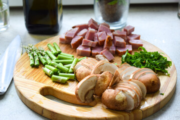 Mushrooms, asparagus and bacon cut on a wooden board.