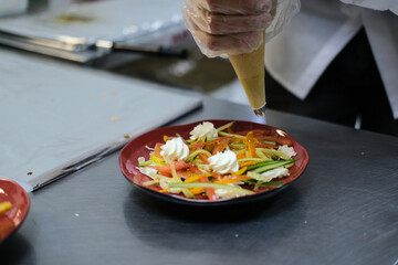 the chef decorates the salad with cheese