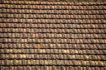 Old, weather-worn roof tiles creating a smooth, geometric texture