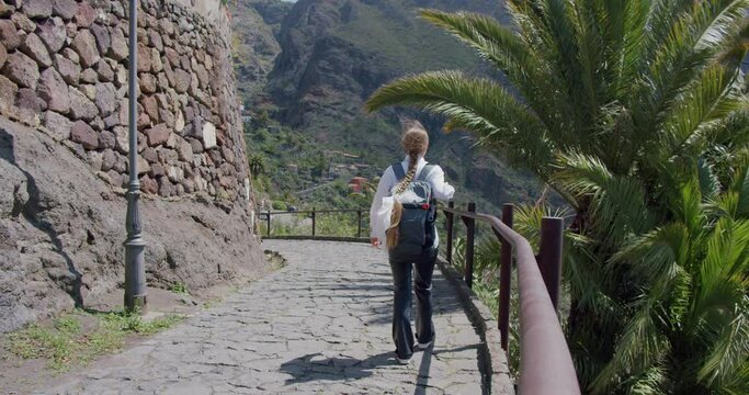 Masca Gorge and village, Tenerife. Beautiful young woman tourist with backpack visit the location.