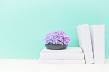 white stationery and wooden vase with fresh flowers on soft green background and light desk.