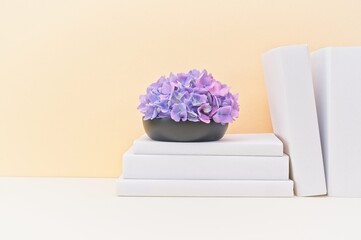 white stationery and wooden vase with fresh flowers on soft beige background and light desk.