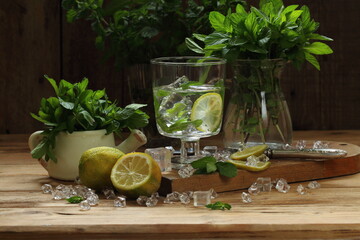 Homemade lemonade with mint and lemon on a wooden background
